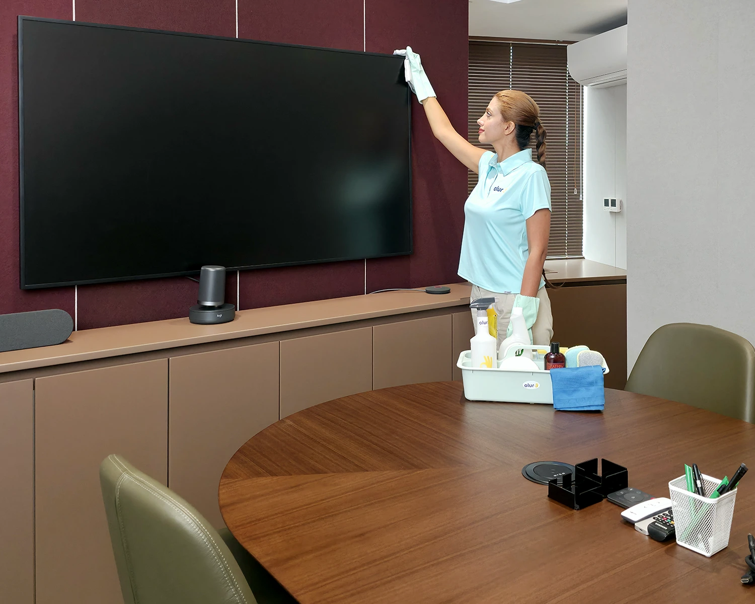 Ofis temizliğinde yukarıdan aşağıya prensibiyle toplantı odasındaki TV ekranının üstü siliniyor